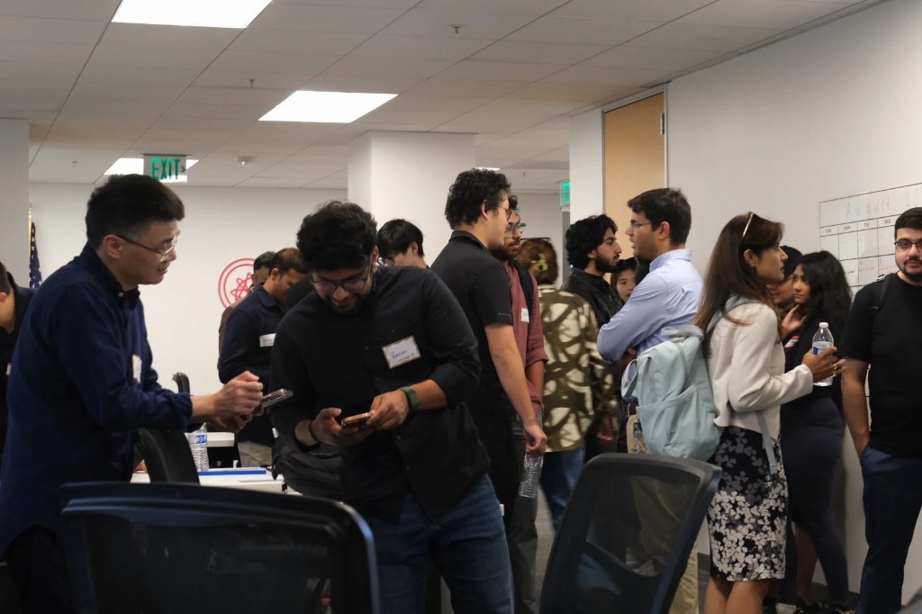 Researchers, founders, and investors talking on the floor at OpenStages AI Tech Salon Night